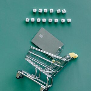 A miniature shopping cart with a credit card illustrates online shopping trends.