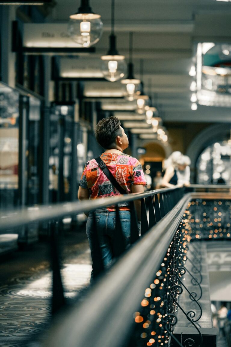Colorful shopping arcade with a fashionable individual walking, showcasing modern architecture.
